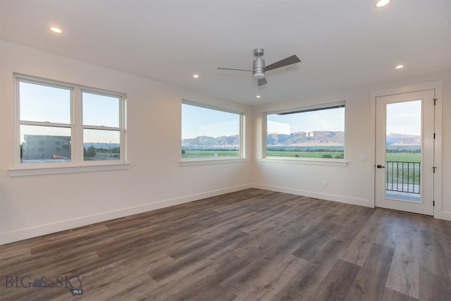 spare room featuring ceiling fan, a mountain view, and dark hardwood / wood-style flooring