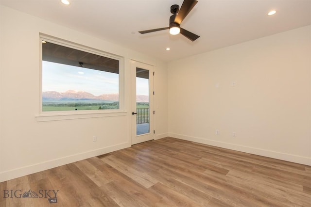 spare room with hardwood / wood-style floors and ceiling fan