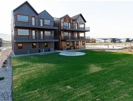 back of house featuring a lawn and a patio