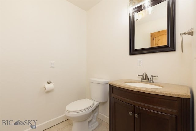 bathroom with toilet, vanity, and tile patterned floors