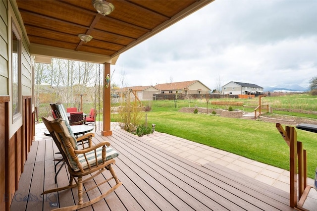 wooden deck with ceiling fan and a yard