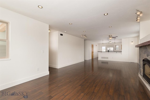 unfurnished living room featuring ceiling fan and dark hardwood / wood-style floors