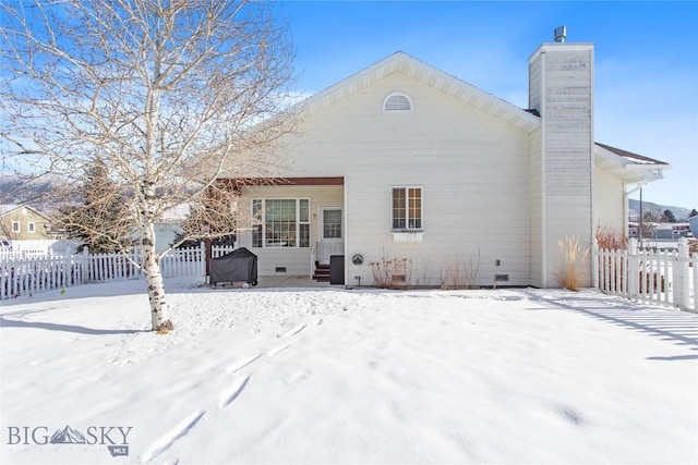 view of snow covered rear of property