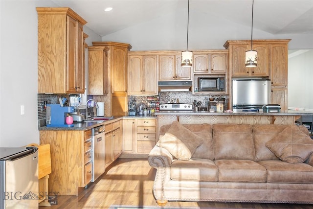 kitchen with stainless steel appliances, decorative light fixtures, lofted ceiling, light hardwood / wood-style floors, and tasteful backsplash