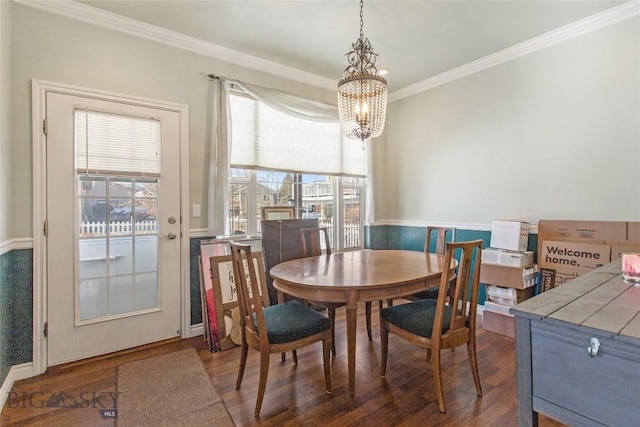 dining space with ornamental molding, dark hardwood / wood-style flooring, and an inviting chandelier