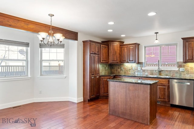 kitchen featuring stainless steel dishwasher, decorative light fixtures, sink, and decorative backsplash