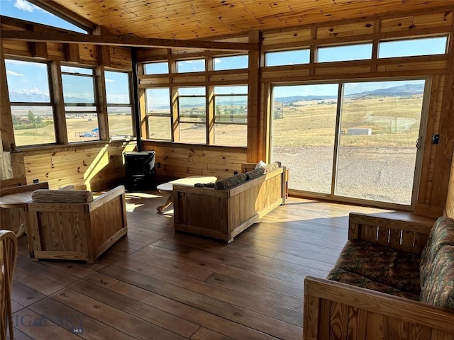 sunroom featuring vaulted ceiling, wooden ceiling, and plenty of natural light