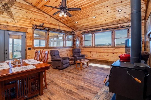 interior space featuring wooden ceiling, wood walls, and a wood stove