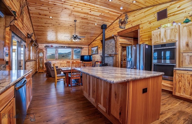 kitchen featuring stainless steel appliances, wooden ceiling, wooden walls, a wood stove, and a kitchen island