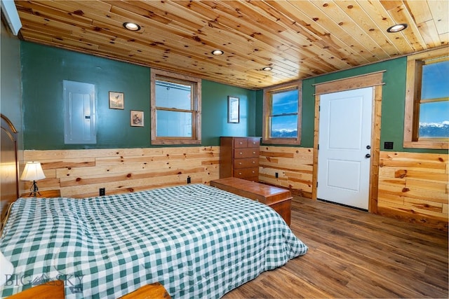 bedroom with wooden walls, hardwood / wood-style flooring, electric panel, and wood ceiling