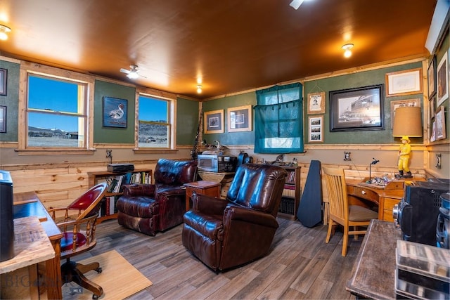 home office featuring wooden walls, ornamental molding, and hardwood / wood-style flooring