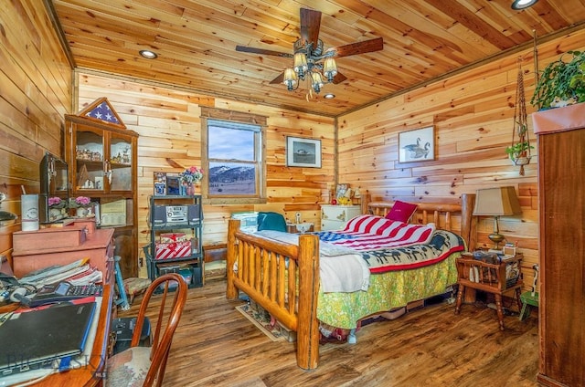 bedroom featuring ceiling fan, wooden ceiling, wood walls, and wood-type flooring