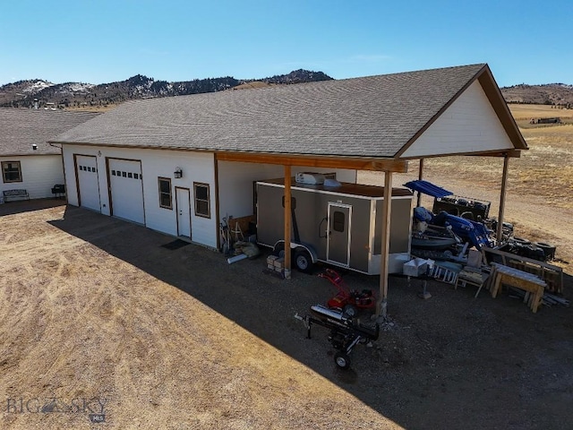 back of property featuring a garage and a mountain view