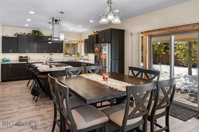 dining area with light hardwood / wood-style flooring and a chandelier