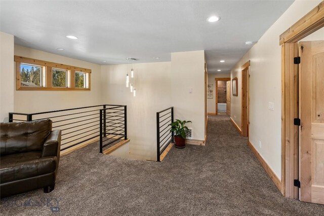 hallway with dark colored carpet