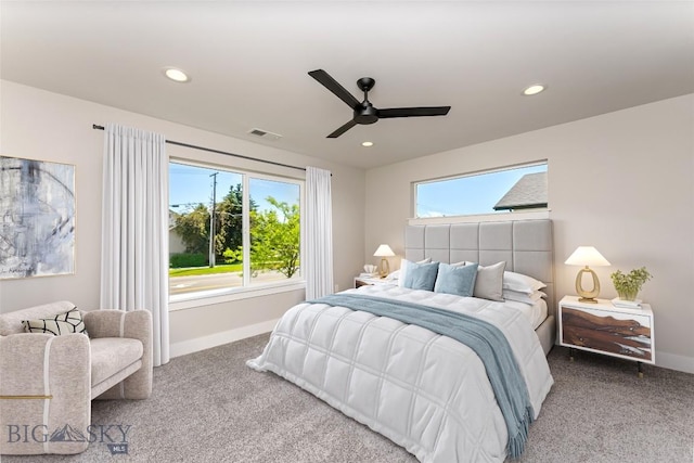 carpeted bedroom with multiple windows and ceiling fan