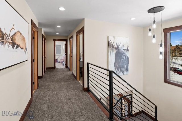 hallway with dark colored carpet