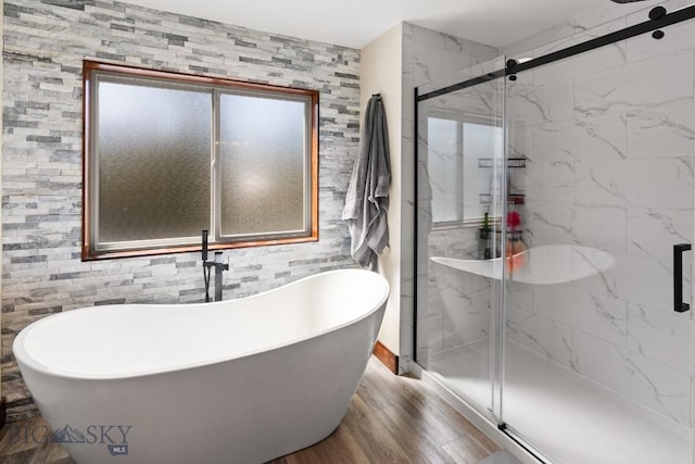 bathroom featuring plus walk in shower and wood-type flooring