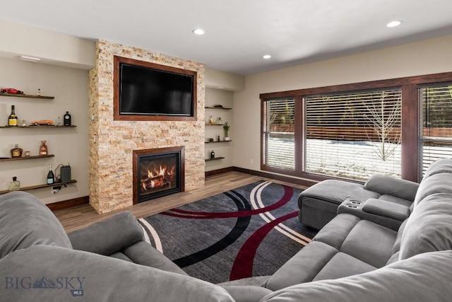 living room featuring hardwood / wood-style floors and a stone fireplace