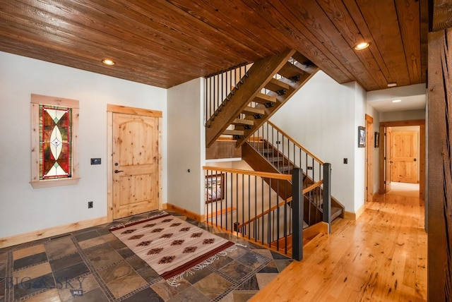 foyer entrance featuring recessed lighting, stairway, baseboards, and wooden ceiling