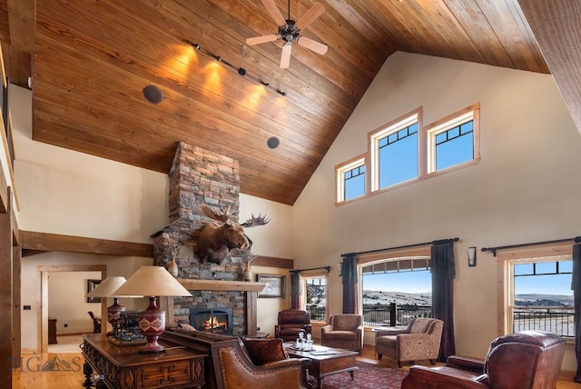 living area with a fireplace, wooden ceiling, wood finished floors, high vaulted ceiling, and a ceiling fan