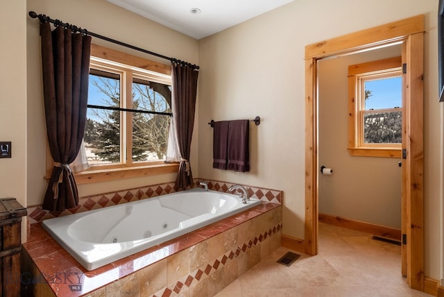 full bathroom featuring visible vents, baseboards, and a whirlpool tub