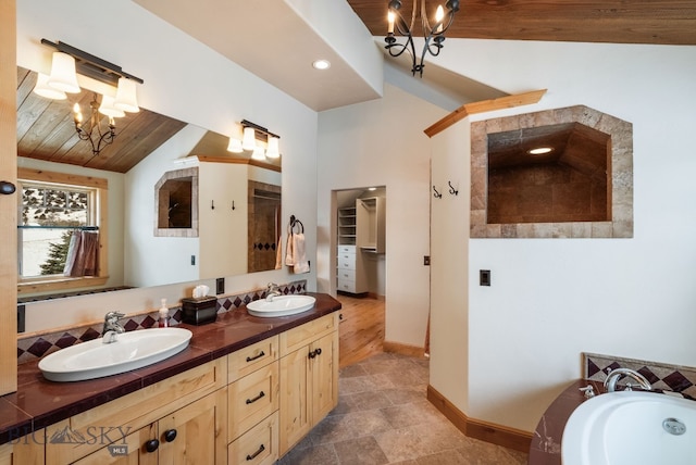 bathroom featuring a chandelier, a shower, lofted ceiling, and a sink