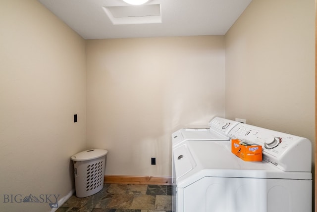 laundry area with stone finish flooring, baseboards, washer and clothes dryer, attic access, and laundry area