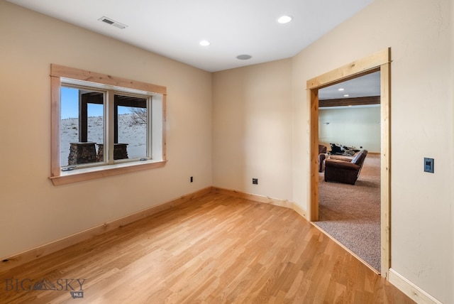 unfurnished room with recessed lighting, wood finished floors, visible vents, and baseboards