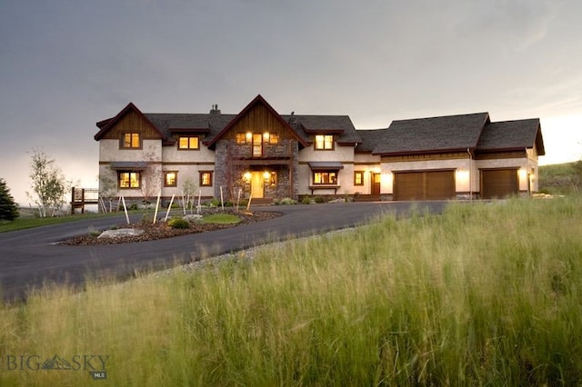 view of front of property featuring a balcony, driveway, and a garage