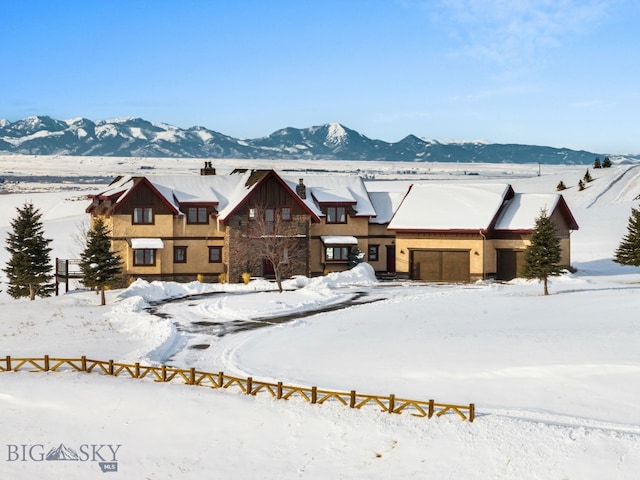 view of front facade featuring a garage, a mountain view, and fence