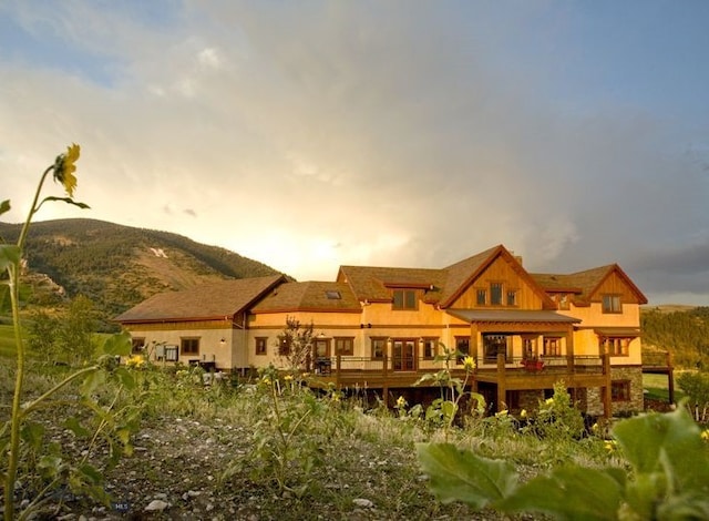 back of property at dusk with a mountain view