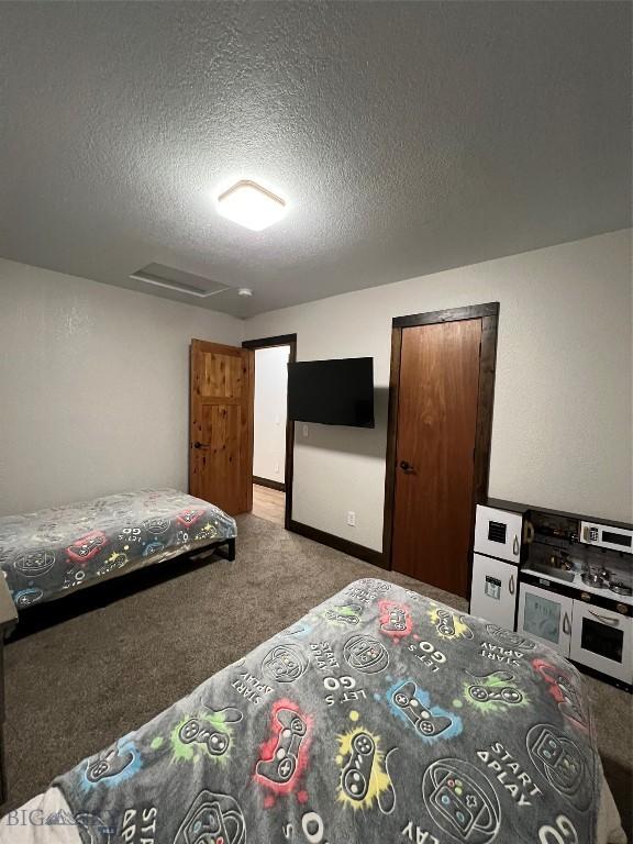 carpeted bedroom featuring a textured ceiling