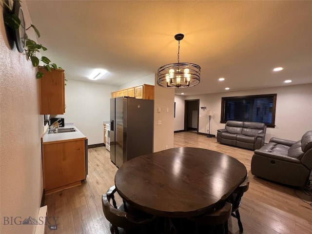 dining room featuring an inviting chandelier, light hardwood / wood-style floors, and sink