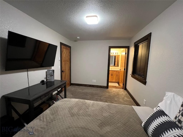 carpeted bedroom featuring a textured ceiling and connected bathroom