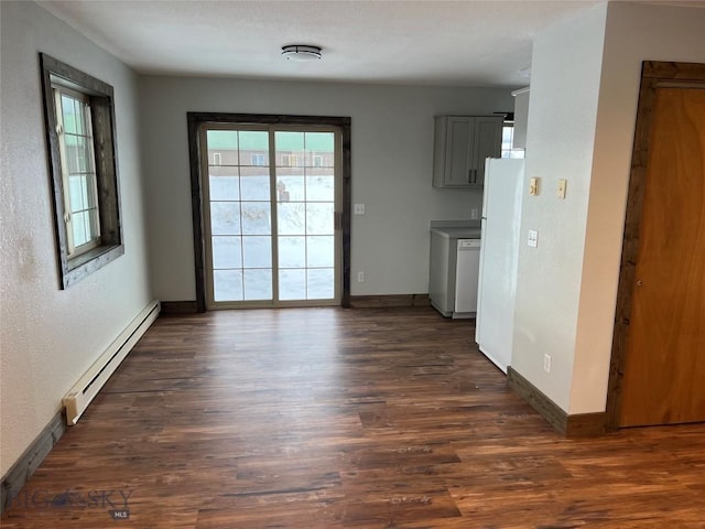 unfurnished dining area featuring a baseboard heating unit and dark hardwood / wood-style flooring