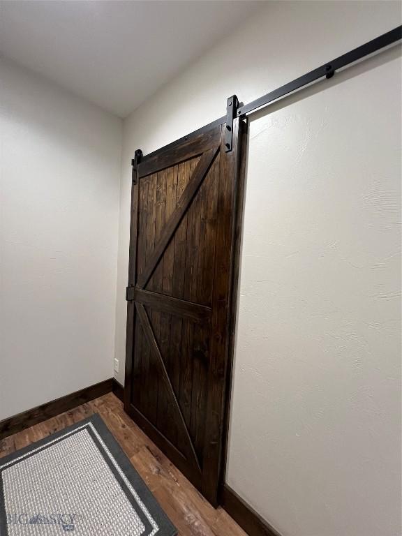 doorway to outside featuring dark wood-type flooring and a barn door