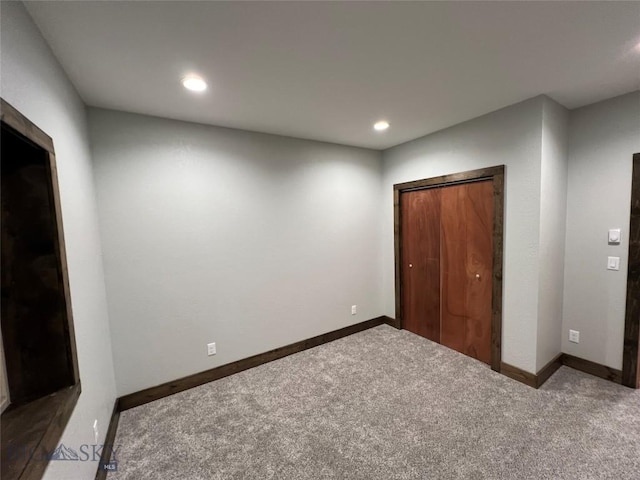 unfurnished bedroom with a closet and dark colored carpet