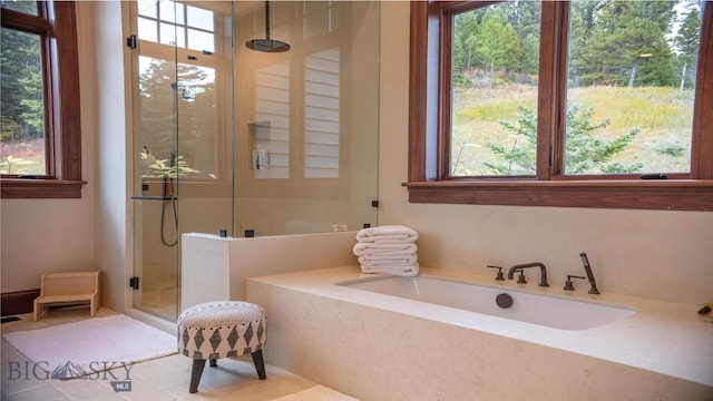 bathroom with tile patterned flooring, shower with separate bathtub, and a wealth of natural light