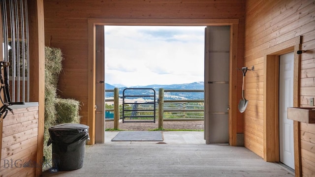 entryway featuring a mountain view and wood walls