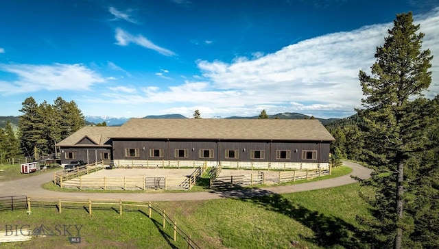 rear view of house with a rural view and a mountain view