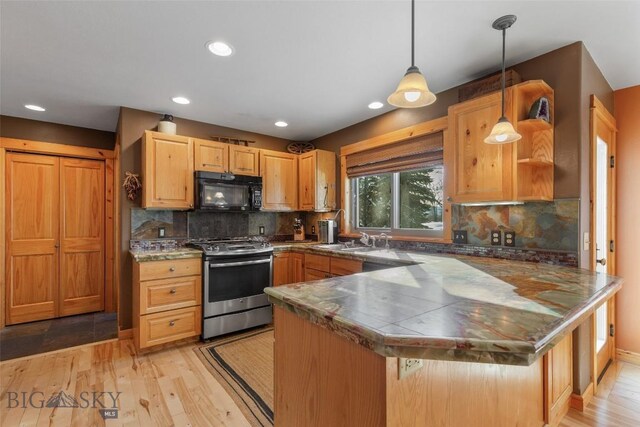 kitchen with kitchen peninsula, stainless steel gas range, decorative backsplash, and pendant lighting