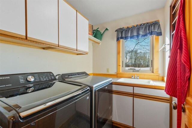 laundry area with washer and dryer, sink, and cabinets