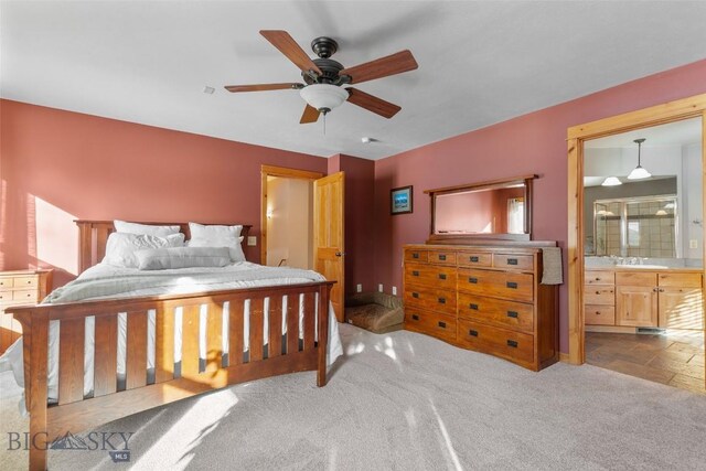 carpeted bedroom featuring ceiling fan, sink, and ensuite bath