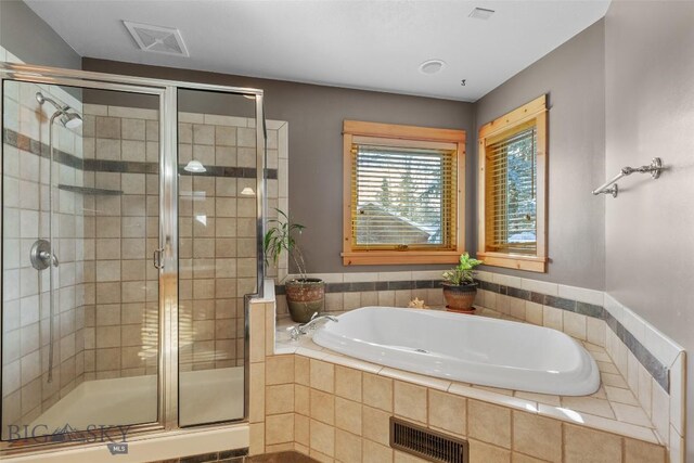 bathroom featuring shower with separate bathtub