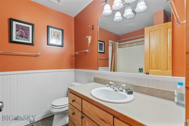 bathroom featuring toilet, tile patterned floors, walk in shower, and vanity