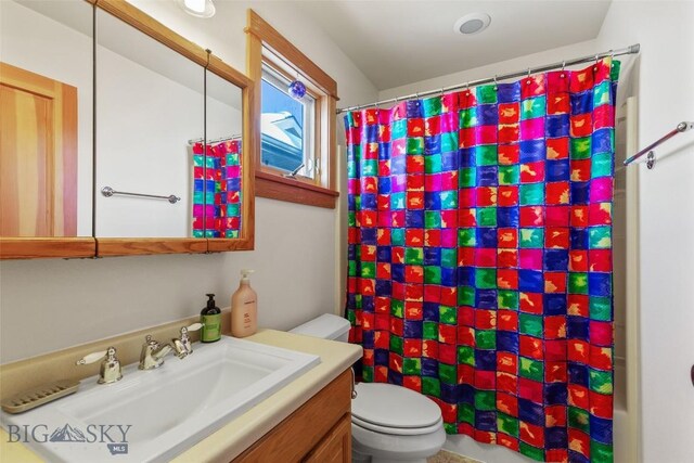 bathroom with curtained shower, toilet, and vanity