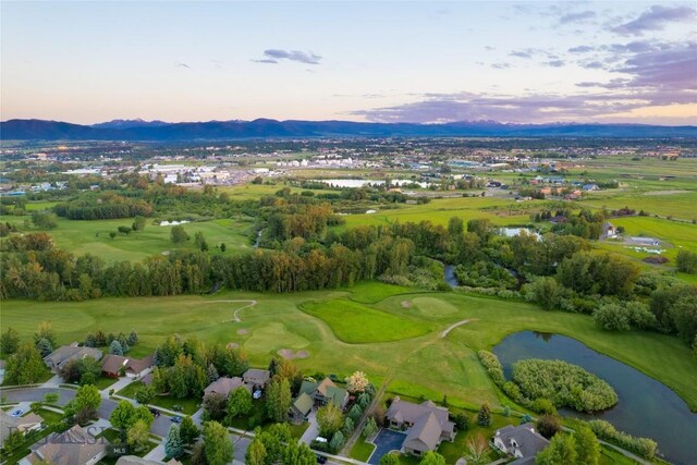 aerial view at dusk featuring a water view