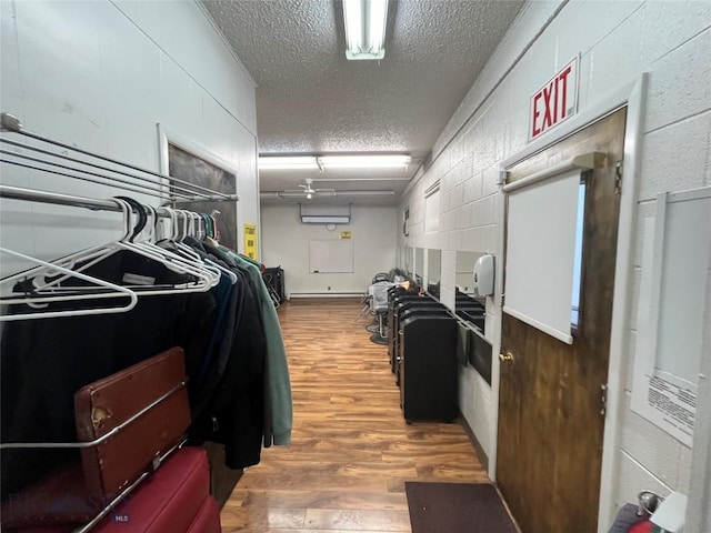 walk in closet with a wall unit AC and hardwood / wood-style flooring