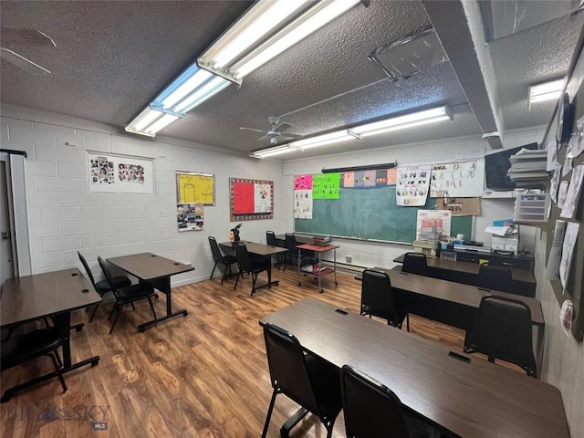 office featuring a textured ceiling, ceiling fan, and wood-type flooring